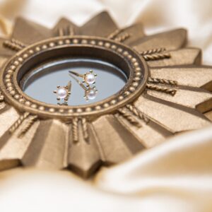 gold sunray pearl studs styled on a mirror with a soft cultured pearl centre