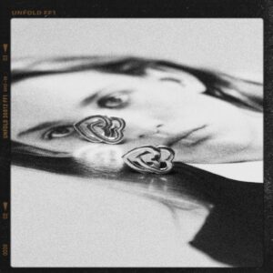 silver double heart stud earrings styled in black and white on a reflective photograph