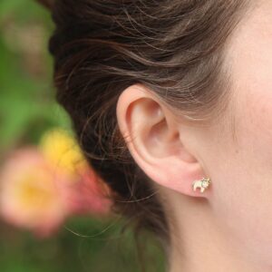 Lifestyle image showing cow stud in ear with soft-focus floral background
